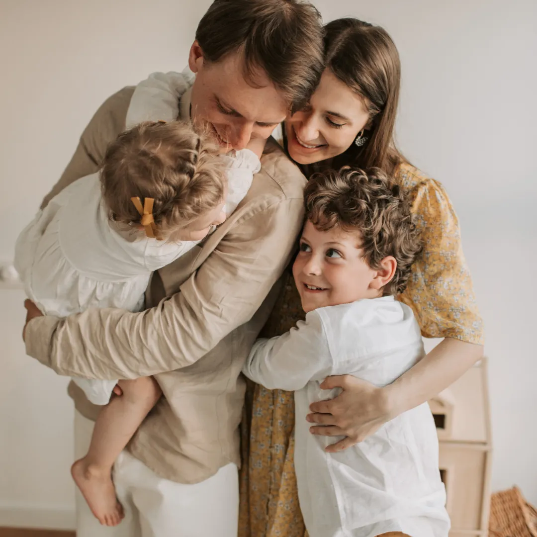Family with young children embracing and smiling