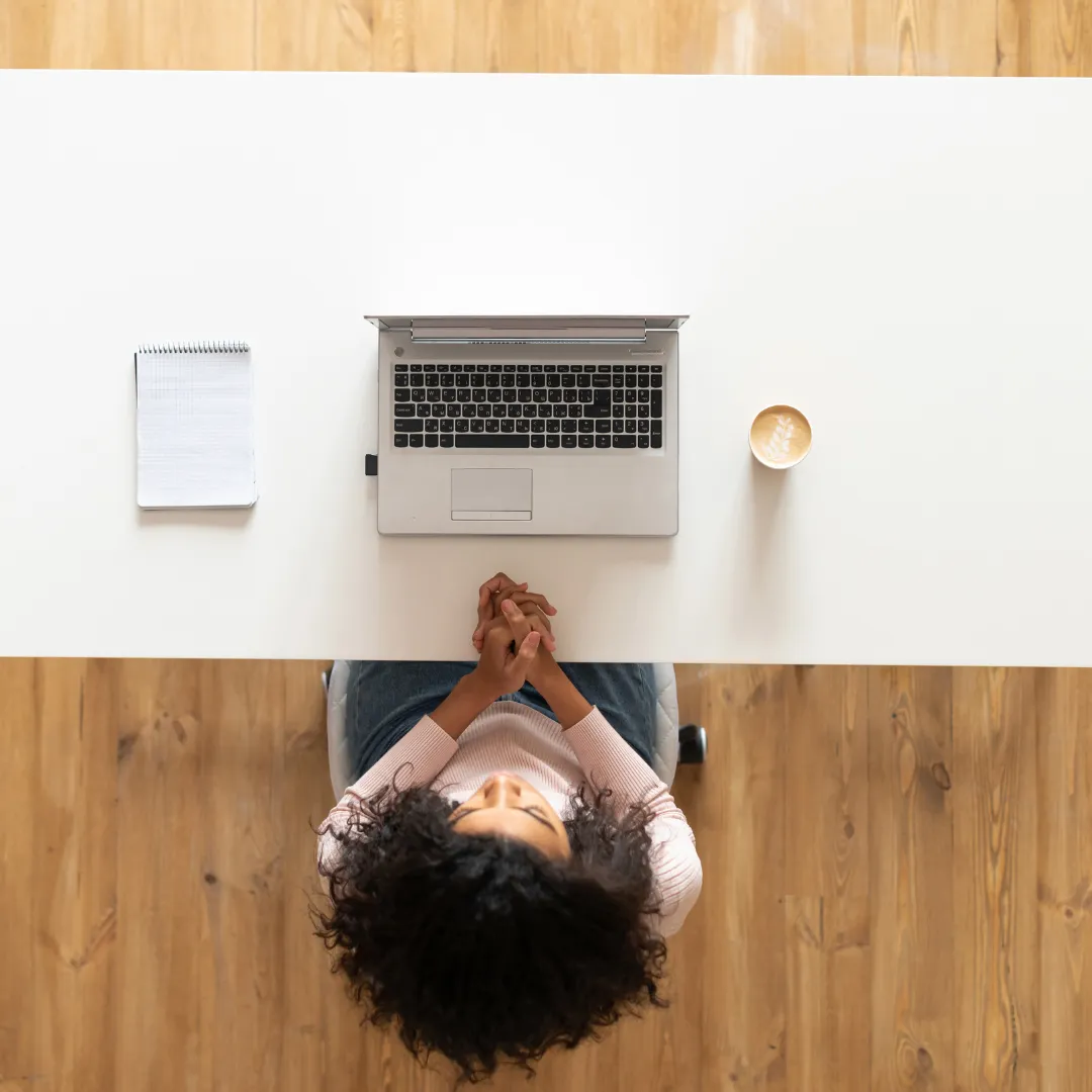 Overhead view of an individual at a desk with a laptop