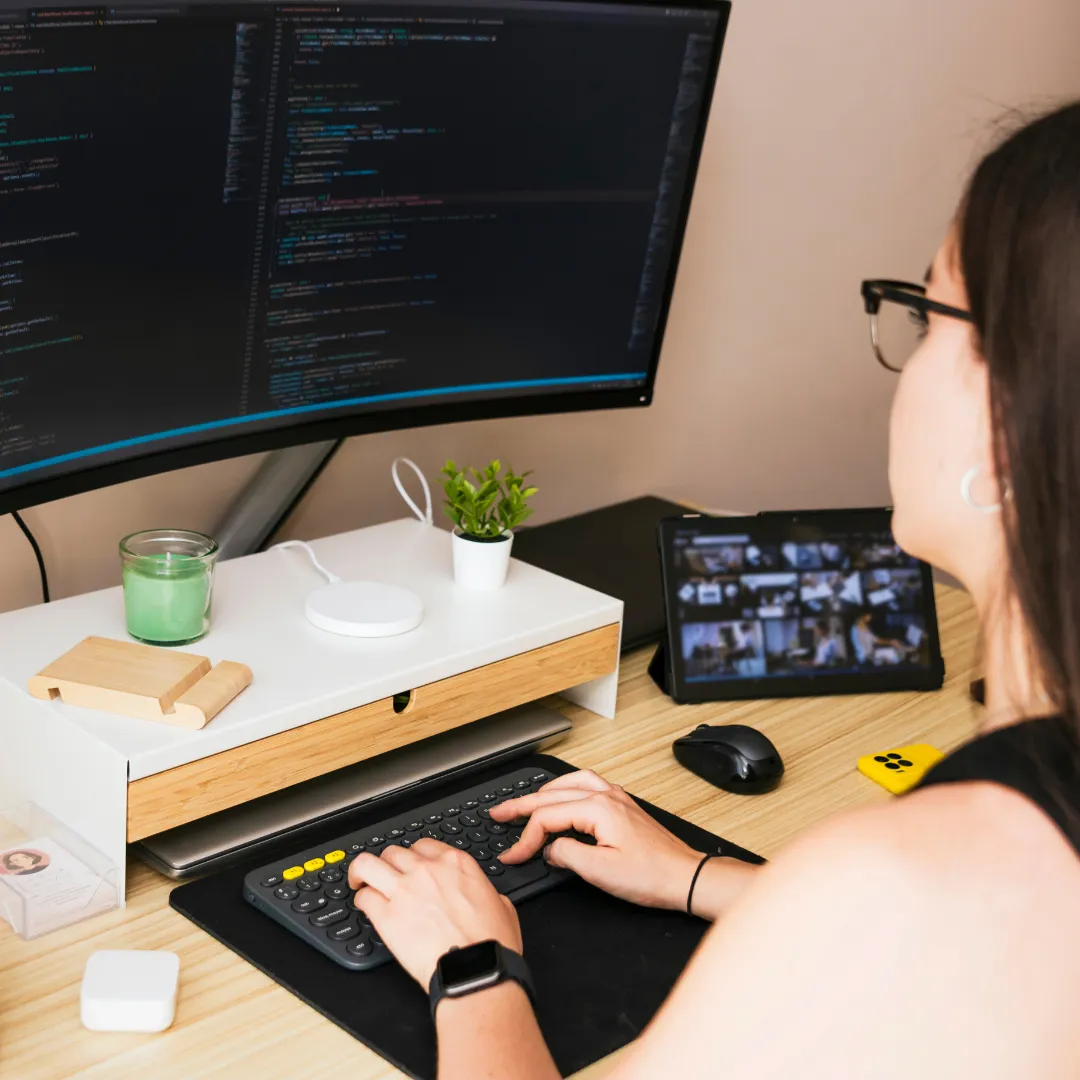 A professional working on multiple computer screens